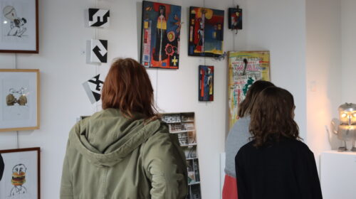 Deux personnes regardant les œuvres exposées dans le cadre de l'exposition.