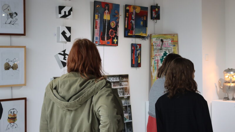 Deux personnes regardant les œuvres exposées dans le cadre de l'exposition.